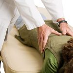 Chiropractor rubbing patient's back Guelph